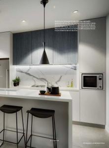 a kitchen with a counter with two bar stools at Unit 103, 1-5 Oxford Street, Blacktown, NSW 2148 in Blacktown