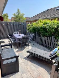 a patio with a table and chairs and a fence at !!!NEU!!! Bungalow Juist in Norddeich 150 m vom Strand in Norddeich +14 photos