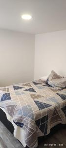a bed with a quilt on it in a room at * APARTAMENTO CON HERMOSA VISTA in Manizales