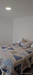 a bed with a quilt on top of it at * APARTAMENTO CON HERMOSA VISTA in Manizales
