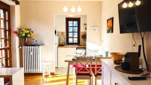 a kitchen and living room with a table and chairs at Hostdomus - Edward Apartment in Cesana Torinese