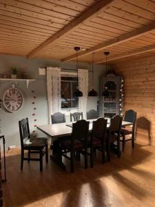 a dining room with a table and chairs and a clock at Aurora House Dåfjord/Tromsø in Karlsøy