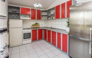a kitchen with red cabinets and white appliances at Gorgeous Apartment In Vir With Kitchen in Vir
