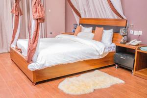 um quarto com uma cama de dossel e um telefone em Hotel Hibiscus em Bujumbura