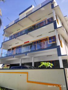 a building with balconies and a car in front of it at Raha homes in Trivandrum