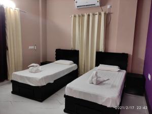 two beds with towels on top of them in a room at Raha homes in Trivandrum