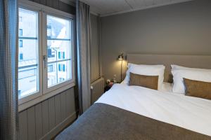 a bedroom with a large bed and a window at Hotel Bergidyll - Riders Haven in Andermatt