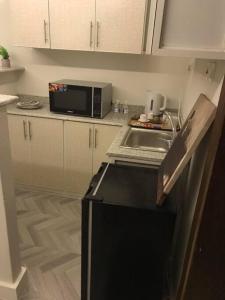 eine Küche mit einem schwarzen Kühlschrank und einer Mikrowelle in der Unterkunft شقه فندقيه غرفه وصاله دخول ذاتى in Riad