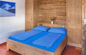 een houten bed met blauwe kussens in een kamer bij Amazing Apartment In Alpbach With 3 Bedrooms And Wifi in Alpbach