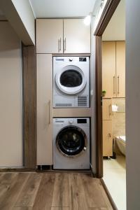 eine Waschmaschine, eine Waschmaschine und ein Trockner im Zimmer in der Unterkunft L&H Apartment in Odorheiu Secuiesc