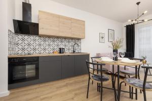 a kitchen and dining room with a table and chairs at Beautiful Studio with Garden and Parking by Renters in Warsaw