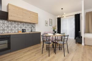 a kitchen and dining room with a table and chairs at Beautiful Studio with Garden and Parking by Renters in Warsaw