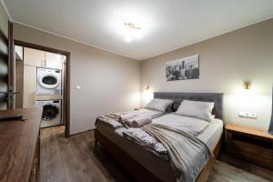 ein Schlafzimmer mit einem Bett und einer Waschmaschine in der Unterkunft L&H Apartment in Odorheiu Secuiesc