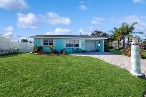 a blue house with a grass yard at Seaside Escape in Ormond Beach