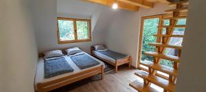 a bedroom with two beds and a window at Rafting Camp Encijan in Foča