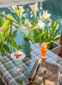 una mesa con una bebida y un jarrón con flores en Seagull Nest Hoi An Beach Village en Tân Thành (1)