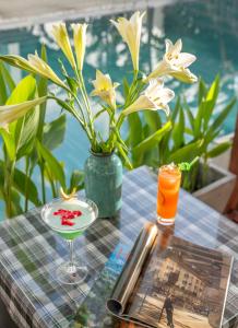 een tafel met een drankje en een vaas met bloemen bij Seagull Nest Hoi An Beach Village in Tân Thành (1)