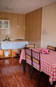una cocina con 2 mesas con mantel rojo y blanco en Cabañas Vaiora en Hanga Roa