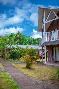 a building with a walkway next to a yard at Cabañas Vaiora in Hanga Roa