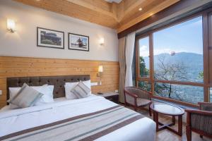 a bedroom with a bed and a large window at Summit Alpine Abode Hotel Centrally Air Conditioned in Gangtok