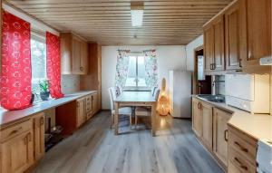 eine kleine Küche mit einem Tisch und einem Kühlschrank in der Unterkunft Awesome Home In Hyltebruk With Wifi in Hyltebruk