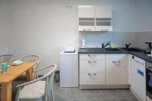 a kitchen with a sink and a table with chairs at Privatpension zur Schwarzach in Greding