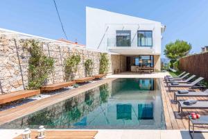 a house with a swimming pool next to a building at Moderna Villa con vistas al mar en Alcudia in Alcudia