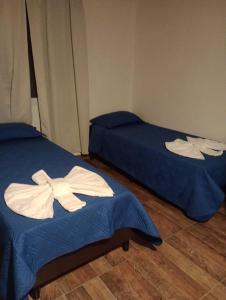 twee bedden met handdoeken erop in een kamer bij EL RANCHO DE PIA in Merlo