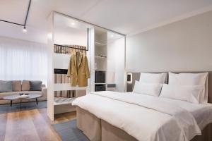 a bedroom with a large white bed and a couch at Apartments am Brandenburger Tor in Berlin