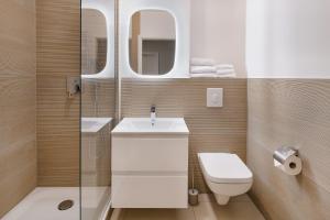 bagno con servizi igienici, lavandino e specchi. di Apartments am Brandenburger Tor a Berlino