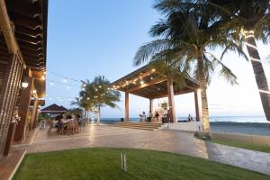 - un restaurant sur la plage avec des palmiers et l'océan dans l'établissement Asaricha Tropical Beach Resort, à Pasuquin