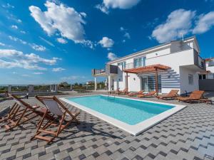 スコシャンにあるApartment in Croatia by the Adriatic Coastの椅子と家のあるプール