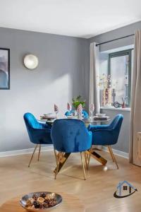 a dining room with blue chairs and a table at 2 bedroom duplex with wifi secure parking sleeps 8 in Nottingham