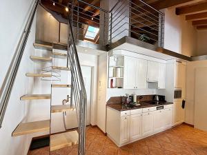 a kitchen with white cabinets and a spiral staircase at Maisonette: 45m2 zum Relaxen, 2 Pers./GP - ME17-B in Pontresina