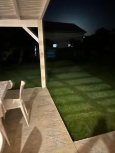 a yard at night with a chair and a lawn at La caraïbe dans la station balnéaire 3 in Saint-François