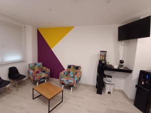 una stanza con due sedie e una parete colorata di Aureo Alojamiento Urbano ad Abarán