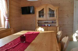 een eetkamer met een houten tafel en een televisie bij kleine Winklerhütte in Tauplitz