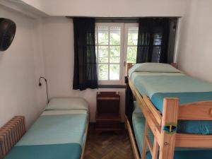 two bunk beds in a small room with a window at Zeppelin Art-Hostel in Mar del Plata