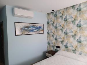 una camera da letto con un letto e un dipinto sul muro di Aureo Alojamiento Urbano ad Abarán