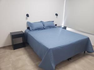 1 dormitorio con 1 cama azul y mesita de noche en Altos del Atuel en San Rafael