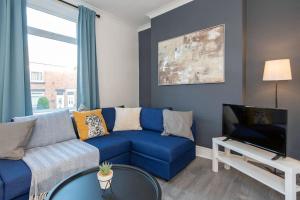 a living room with a blue couch and a table at Prospect Terrace in New Brancepeth