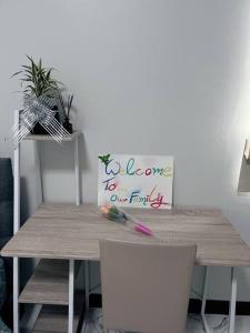 a wooden table with a sign that says welcome to our family at Chaya Home&Hug Phrae in Phrae
