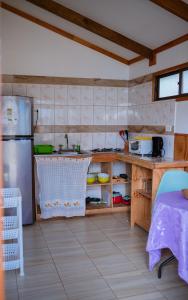 a kitchen with a sink and a refrigerator at Cabañas Vaiora in Hanga Roa