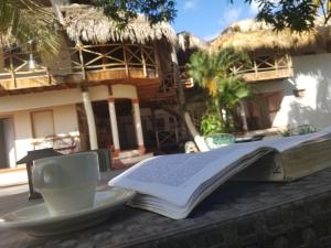 an open book on a table with a cup of coffee and an open book gmaxwell at Jardín del Coco in Las Galeras
