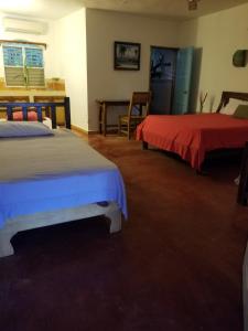 a bedroom with two beds and a table and chairs at Jardín del Coco in Las Galeras