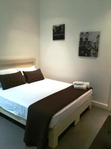 レッジョ・ディ・カラブリアにあるCasual Stay Galileoのベッドルーム(白い大型ベッド、黒い枕付)