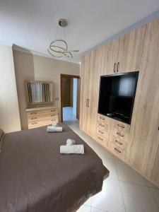 1 dormitorio con 1 cama grande y TV de pantalla plana en Home Sweet Home, en Elbasan