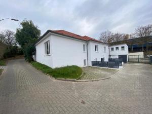 una casa blanca con una entrada delante de ella en ROYAL OCEAN Ferienhaus mit Sauna, Spielekonsole und Whirlpool en Rostock
