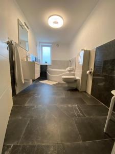 a bathroom with a tub and a toilet and a sink at ROYAL OCEAN Ferienhaus mit Sauna, Spielekonsole und Whirlpool in Rostock