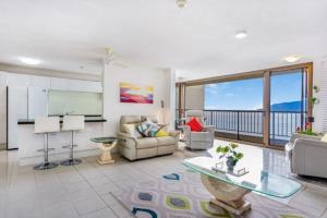 uma sala de estar com um sofá e uma mesa em Cairns Ocean View Apartment in Aquarius em Cairns